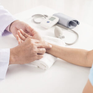 Doctor touching female hand to check pulse